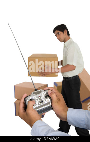 Person's hands controlling a worker with a remote control Stock Photo