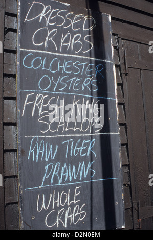 Blackboard outside black tarred fishermans hut advertising shellfish seafood for sale Stock Photo