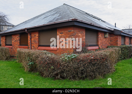 Closed metal roller security blinds on a small shop building Stock Photo