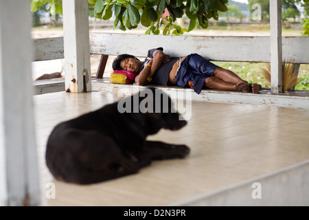 A dog and a man asleep in Thong Sala , Koh Phangan , Thailand Stock Photo