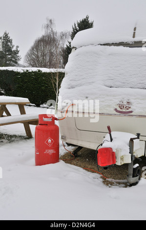 Caravan in an all season caravan park photographed during january's snow fall, Propane gas -bottle used use during colder months Stock Photo