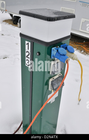 Electric console for supplying 240 volt supply to caravans in an all season caravan park photographed during january's snow fall Stock Photo