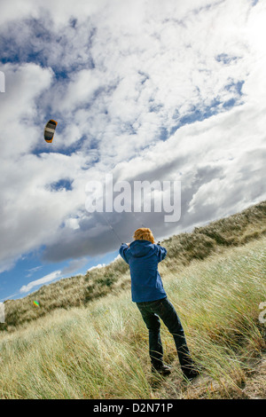 Young man flying kite, Schiermonnikoog, West Frisian Islands, Friesland, The Netherlands (Holland), Europe Stock Photo
