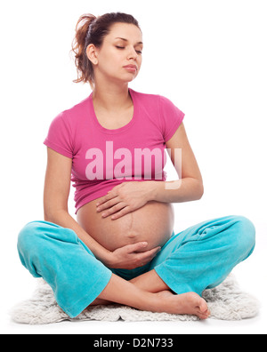 Pregnant woman dreams keeping hands on her belly. Isolated on a white background. Stock Photo