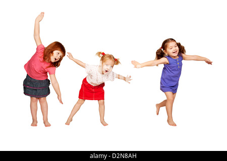 Happy little children dancing in air. Red-haired, blonde and brunette girls. Joyful party. Isolated on white background. Stock Photo