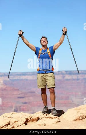 Successful young fit strong caucasian man hiker reaching Grand Canyon south rim summit goal Stock Photo