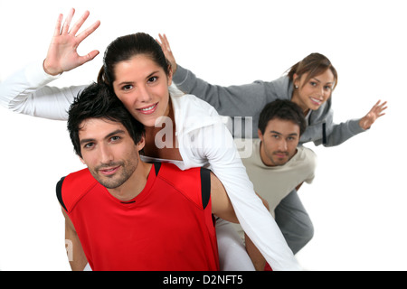 young men giving their girlfriends a piggy back ride Stock Photo