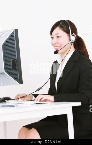 Businesswoman with headset using computer Stock Photo