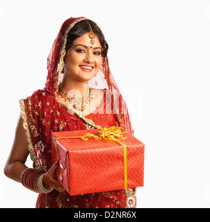Bride in traditional wedding dress and holding a gift Stock Photo
