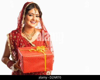Bride in traditional wedding dress and holding a gift Stock Photo