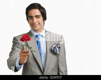 Portrait of a businessman offering a red rose Stock Photo