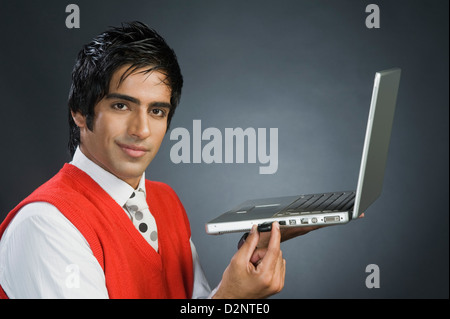 Businessman plugging in a USB device into a laptop Stock Photo
