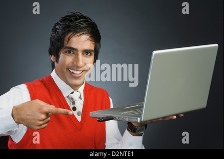 Businessman pointing at a USB device attached to a laptop Stock Photo