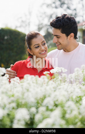 Couple smiling among flowers Stock Photo