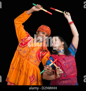 Couple performing dandiya Stock Photo