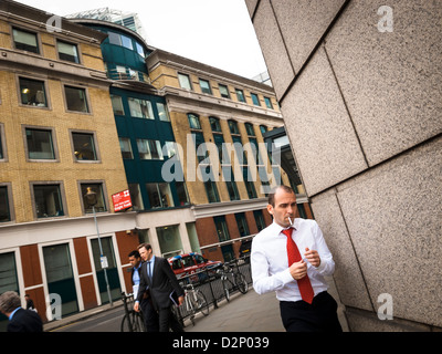 a man in white shirt is going to smoke in a morning in the City, London Stock Photo