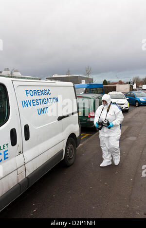 A forensic investigator takes photos at the scene of a suspected crime. Stock Photo