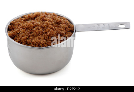 Dark brown soft / muscovado sugar presented in an American metal cup measure, isolated on a white background Stock Photo
