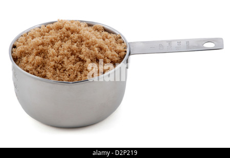 Light brown soft / muscovado sugar presented in an American metal cup measure, isolated on a white background Stock Photo