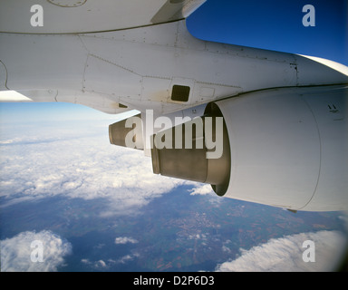 Jet engines of a modern aircraft in flight over partly cloudy UK landscape. Stock Photo
