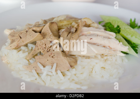 rice steamed with chicken soup served with chicken and liver over rice and cucumber , thai name ' kao mon kai' Stock Photo