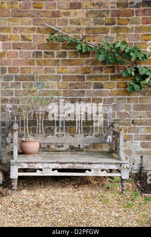 Garden bench in front of a brick wall Stock Photo - Alamy