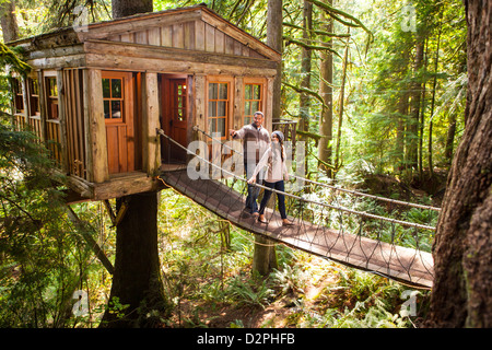 Couple on walkway of remote tree house Stock Photo