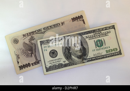 10000 yen banknotes and 100 dollar banknotes Stock Photo