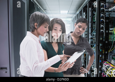 Businesswomen working together in server room Stock Photo