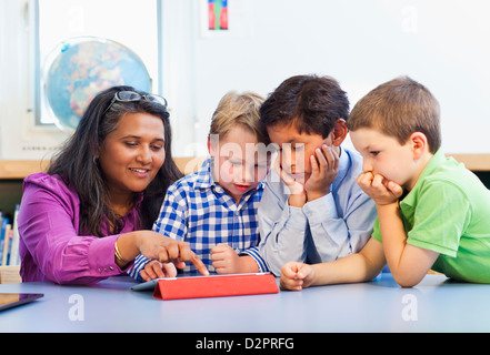 Teacher and students using digital tablet Stock Photo