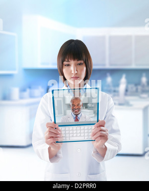 Mixed race doctor using digital tablet in doctor's office Stock Photo