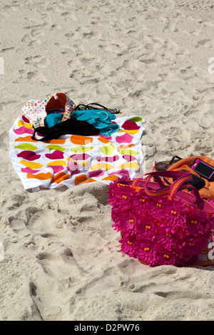 Beach towels and accessories lying on sand Stock Photo