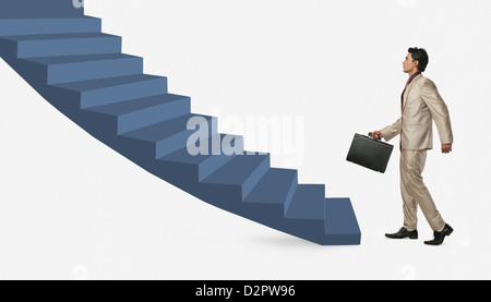 Businessman moving up staircase Stock Photo