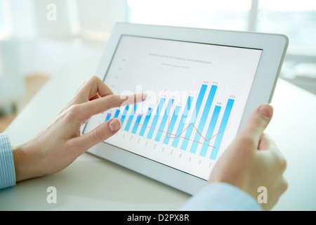 Female worker analyzing financial results with the help of a digital pad Stock Photo