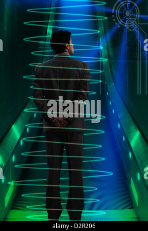 Rear view of a businessman standing on a moving walkway Stock Photo