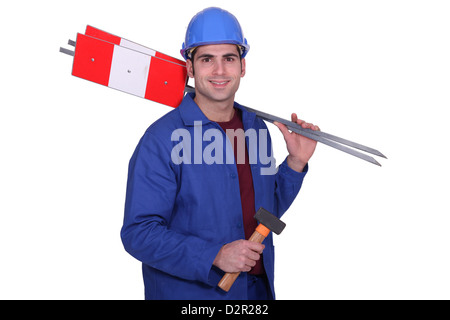 Road worker holding signs and hammer Stock Photo