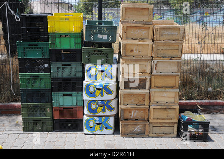 Empty boxes stacked on street against wire. Stock Photo