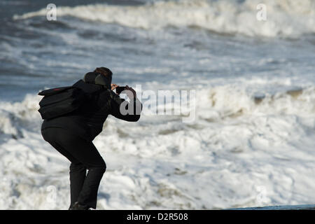 Aberystwyth Wales UK.  January 31 2013  A man photographs the  wave as gale force winds and stormy seas batter the seafront and beach at Aberystwyth on the west Wales coast.   photo ©keith morris Stock Photo
