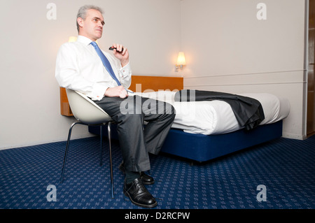 Business man sitting alone in hotel room. Stock Photo