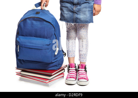 8 year old school girl with books and backpack on white background Stock Photo