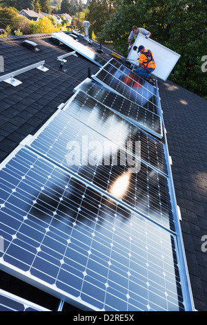 Caucasian men installing panels on roof Stock Photo