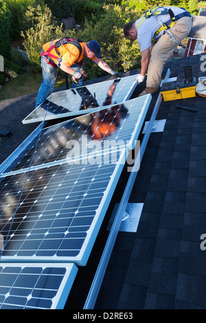 Caucasian men installing panels on roof Stock Photo