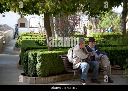 Visitors enjoying the high level parterre gardens in the Generalife complex of the Alhambra in Granada Andalucia Spain Stock Photo