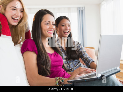 Smiling women using laptop together Stock Photo