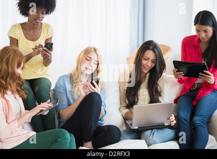 Women using technology on sofa Stock Photo