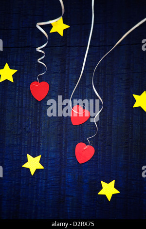 Shiny gold stars and red love hearts on a blue wood background Stock Photo