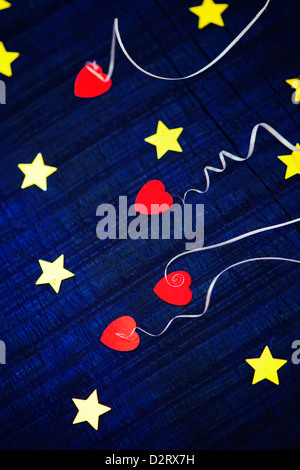 Shiny gold stars and red love hearts on a blue wood background Stock Photo