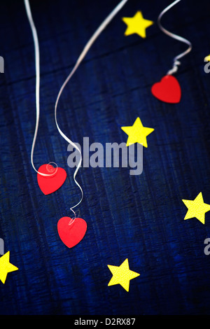 Shiny gold stars and red love hearts on a blue wood background Stock Photo