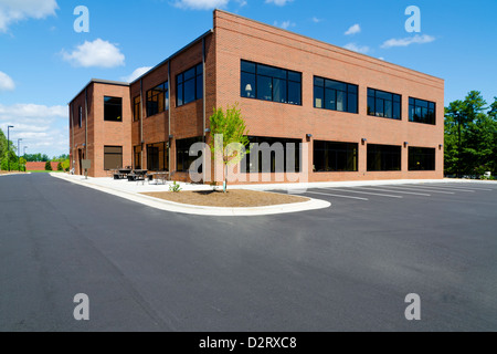 Side view on the generic red brick office building with parking lot ...