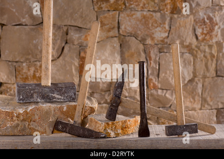 Hammer mason tools of stonecutter masonry work in a contruction stone wall Stock Photo